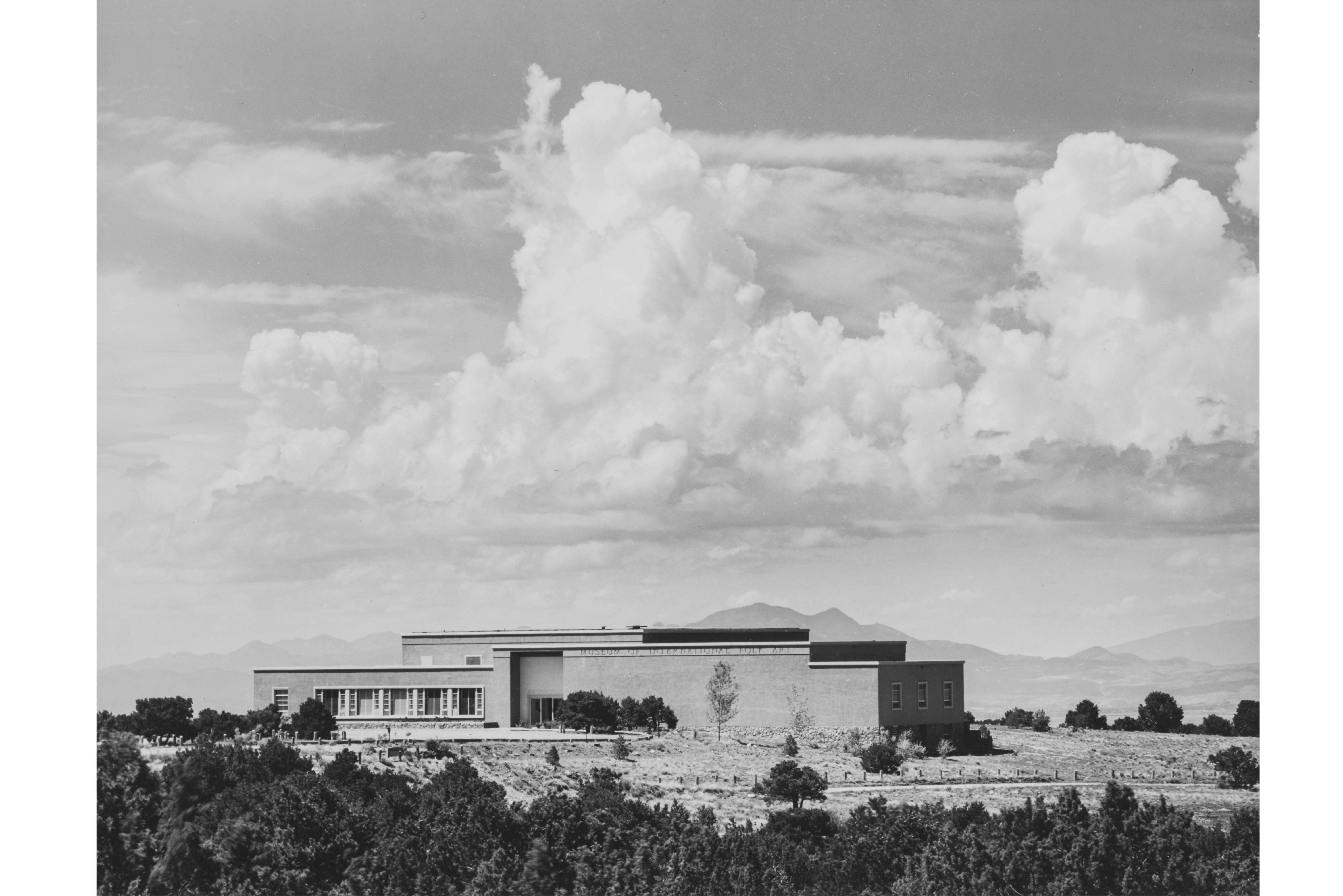 image of the Museum exterior, showing it settled into the landscape under a dramatic cloudbank