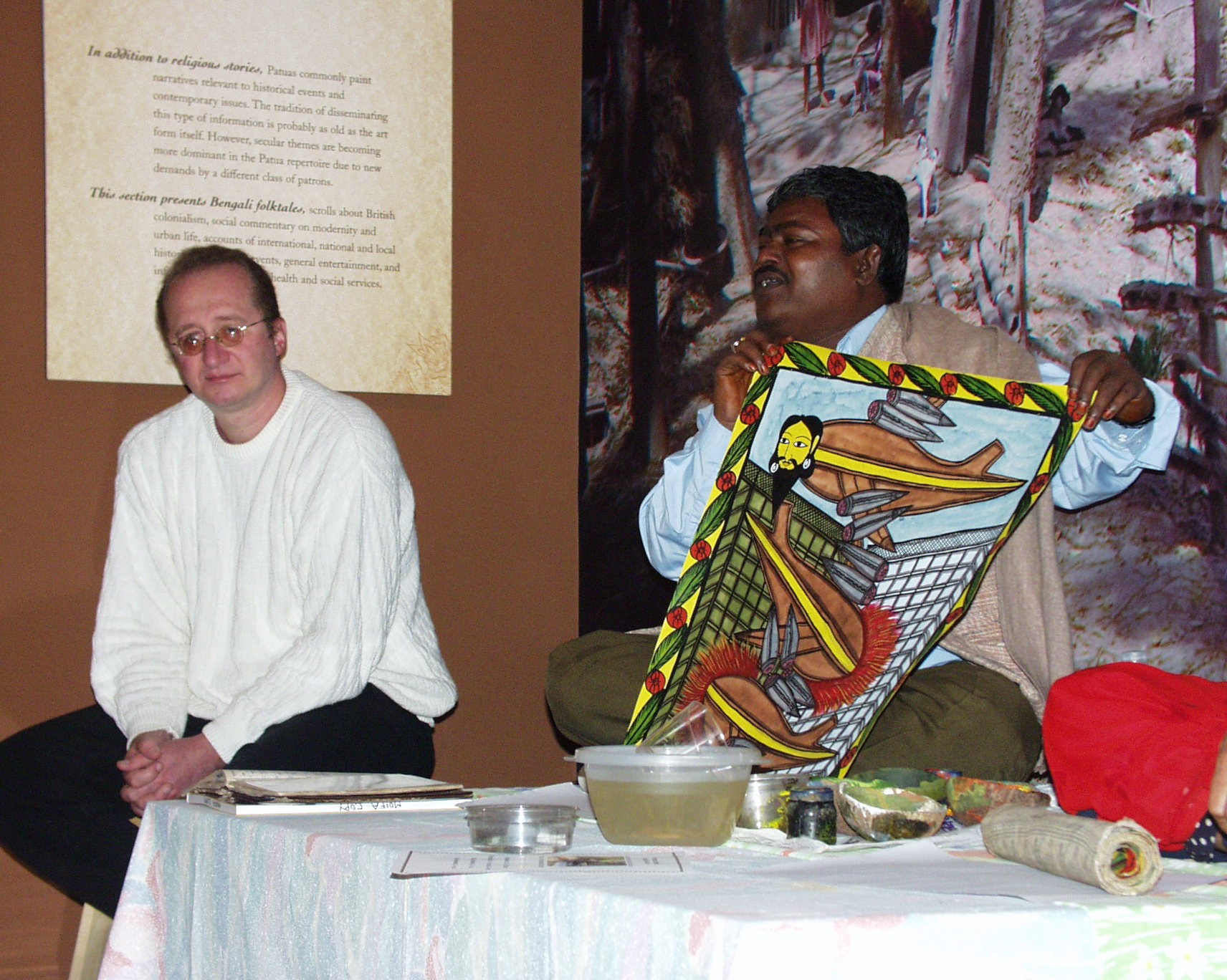 Curator Frank Korom with artist Gurupada Chitrakar painting a scroll.